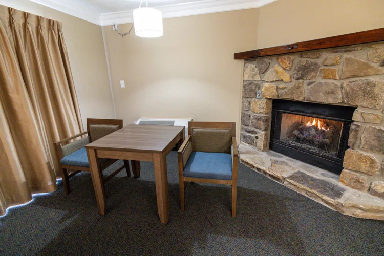 Norma Dan Motel King Room with Fireplace and/or Jacuzzi table and chairs next to fireplace
